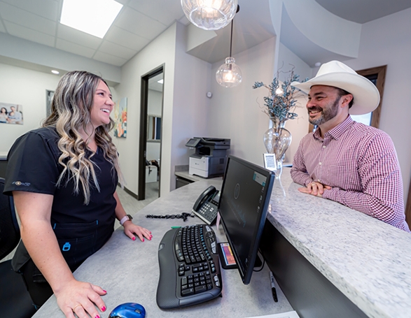 Man in a cowboy hat checking in at the dental office
