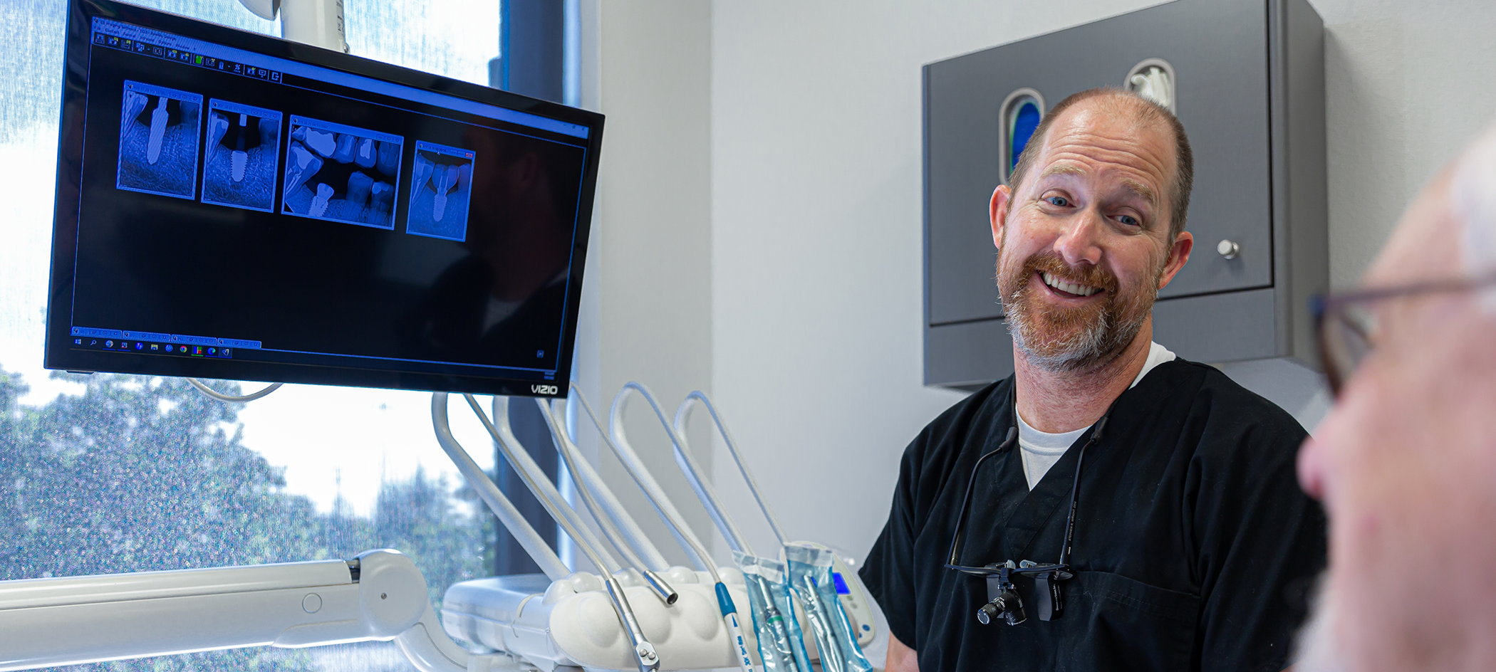 Dentist talking to a patient about dental implants in College Station
