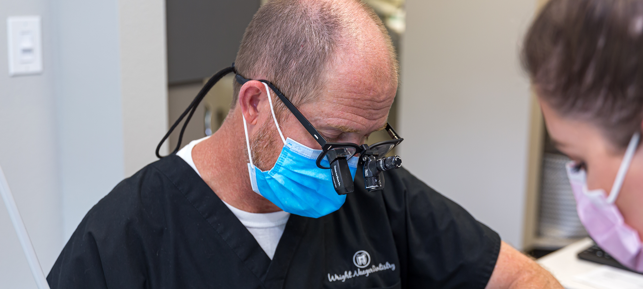 Dentist and assistant performing gum disease treatment on a patient