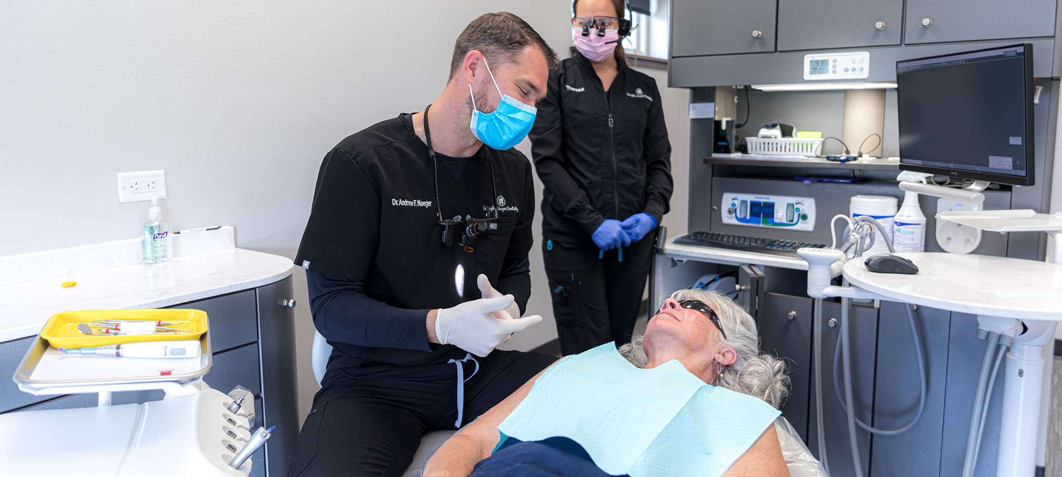 Dentist talking to a senior woman patient about replacing missing teeth