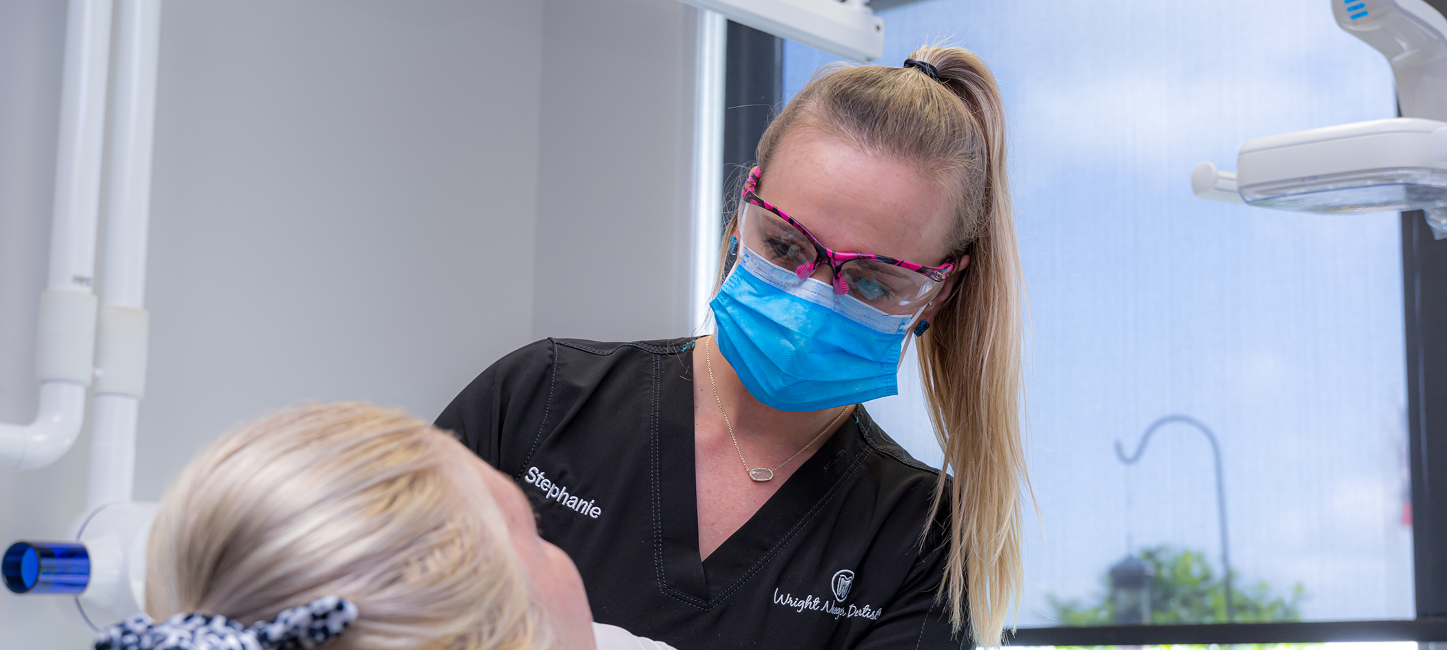 Dental team member talking with a patient in the treatment chair