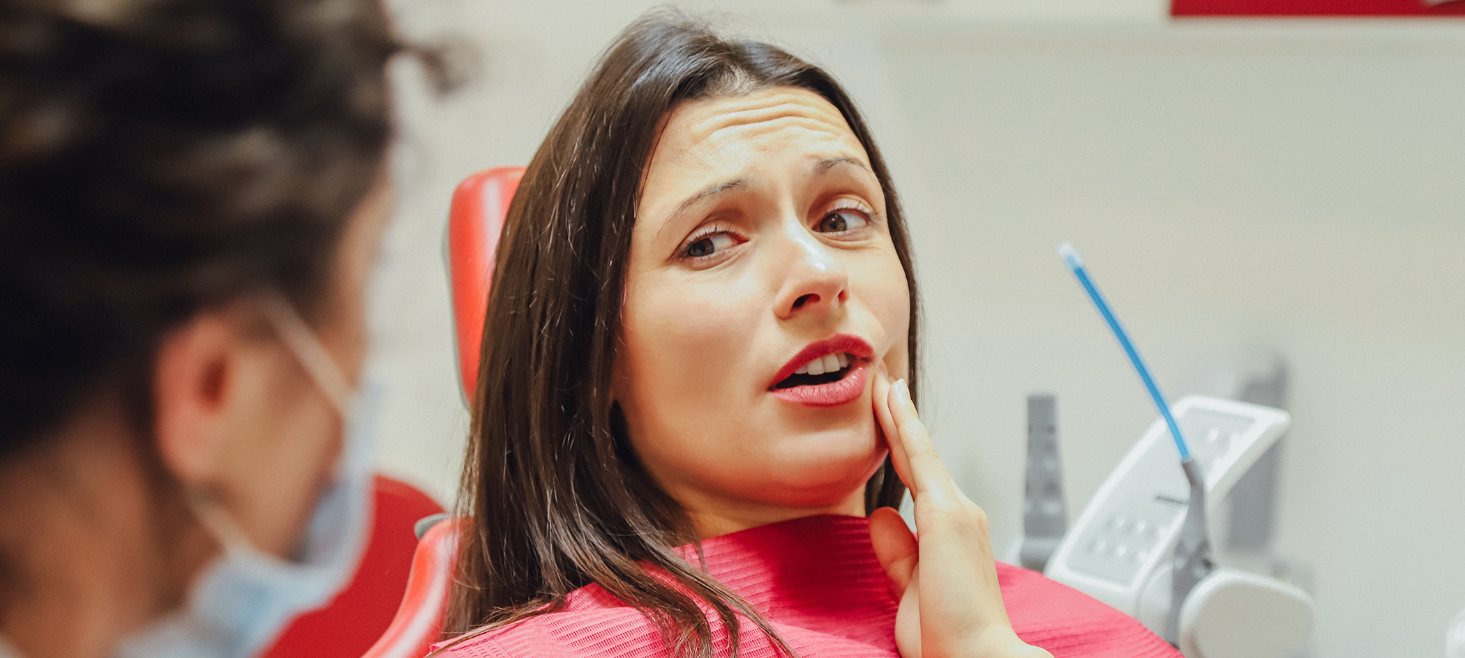 Dental patient holding her cheek in pain before root canal treatment