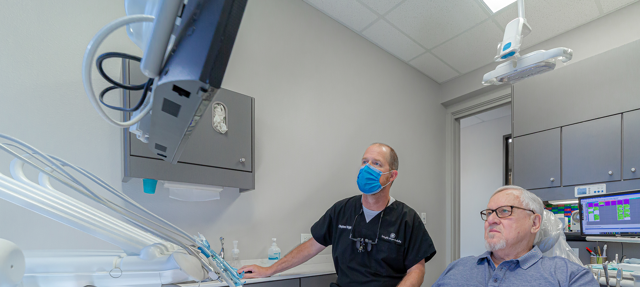 Dentist talking with a patient about TMJ treatment in College Station